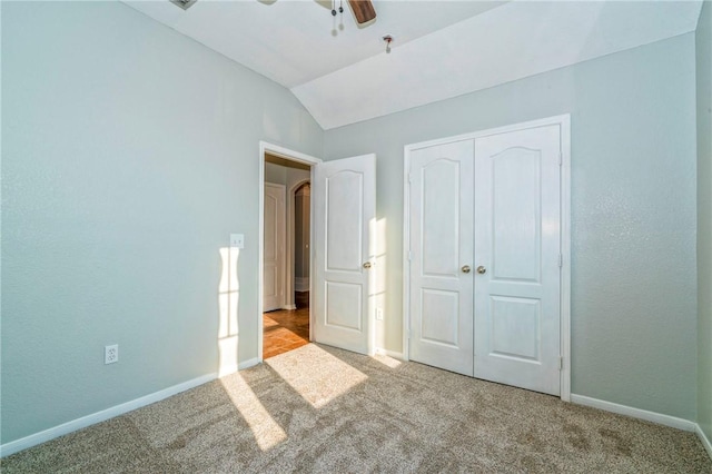 unfurnished bedroom with lofted ceiling, light colored carpet, ceiling fan, and a closet