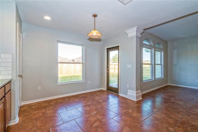 unfurnished dining area featuring decorative columns