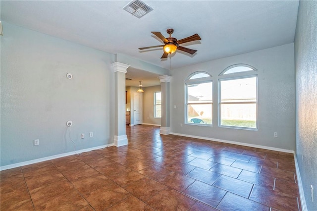 spare room featuring decorative columns and ceiling fan