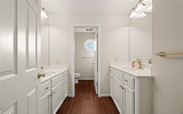 bathroom with wood-type flooring, vanity, and toilet