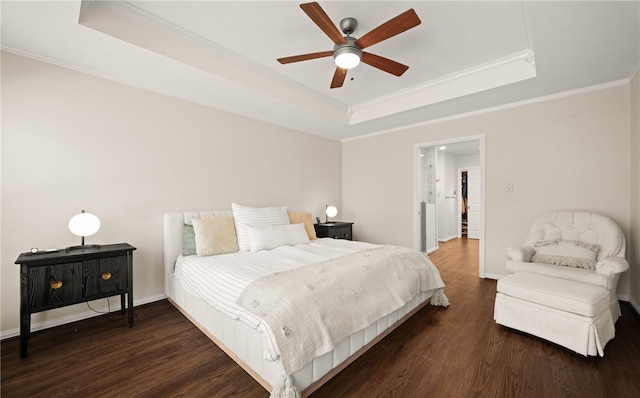 bedroom with crown molding, dark wood-type flooring, a raised ceiling, and ceiling fan