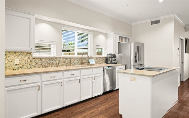 kitchen featuring sink, appliances with stainless steel finishes, white cabinetry, a center island, and light stone counters