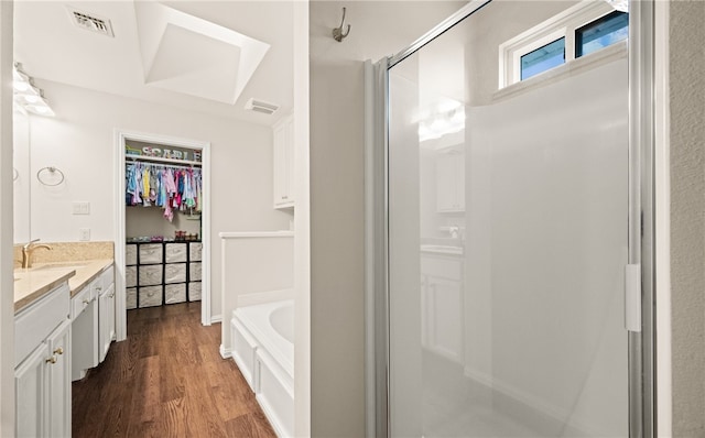 bathroom featuring hardwood / wood-style flooring, vanity, and independent shower and bath