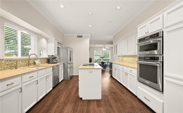 kitchen with sink, white cabinetry, a center island, stainless steel appliances, and light stone countertops