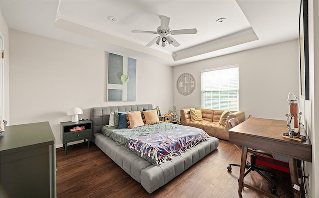 bedroom with dark wood-type flooring, ceiling fan, crown molding, and a raised ceiling