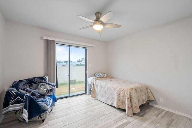 bedroom featuring a water view, ceiling fan, light hardwood / wood-style flooring, and access to outside