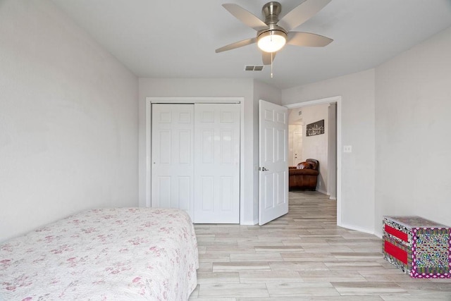 bedroom featuring ceiling fan, light hardwood / wood-style floors, and a closet