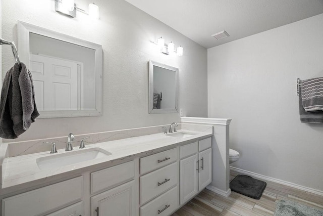 bathroom featuring vanity, hardwood / wood-style floors, and toilet