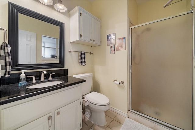 bathroom with tile patterned flooring, vanity, toilet, baseboards, and a stall shower