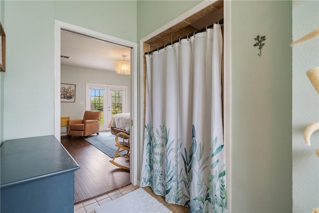 full bathroom with a shower with shower curtain and french doors
