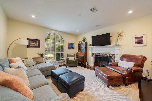 living room with recessed lighting, wood finished floors, and visible vents