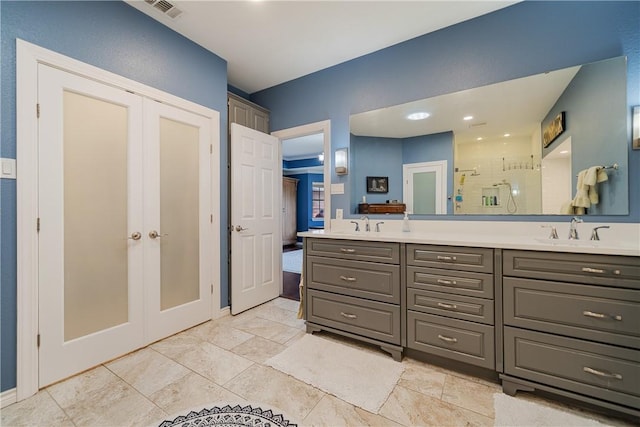 bathroom with a sink, french doors, a stall shower, and visible vents