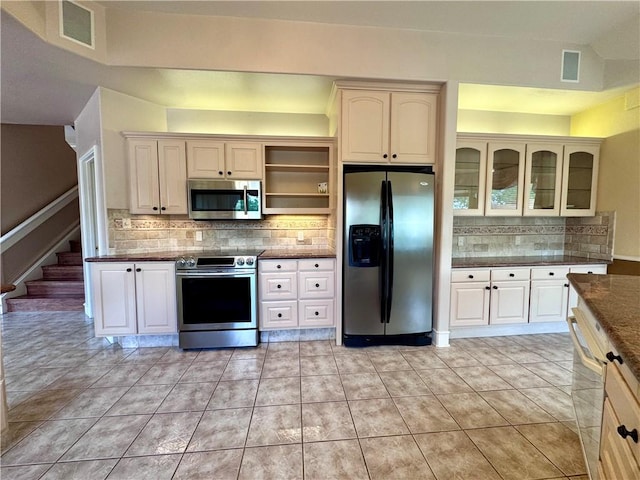 kitchen with visible vents, open shelves, stainless steel appliances, and tasteful backsplash