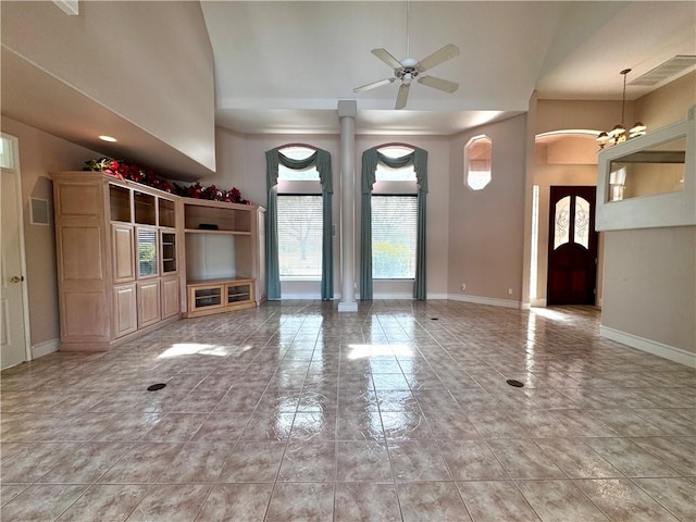 unfurnished living room with arched walkways, ceiling fan, visible vents, and baseboards