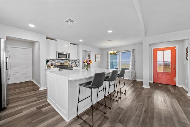 702 W 1st St, Bishop, TX 78343 - kitchen featuring dark wood-type flooring, visible vents, white cabinetry, and appliances with stainless steel finishes