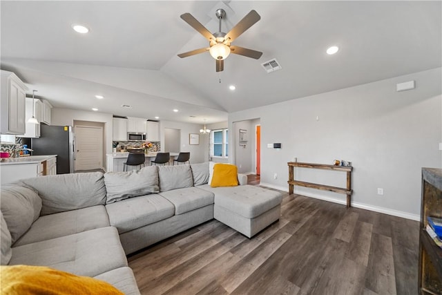 702 W 1st St, Bishop, TX 78343 - living area with dark wood-style flooring, baseboards, visible vents, lofted ceiling, and ceiling fan with notable chandelier