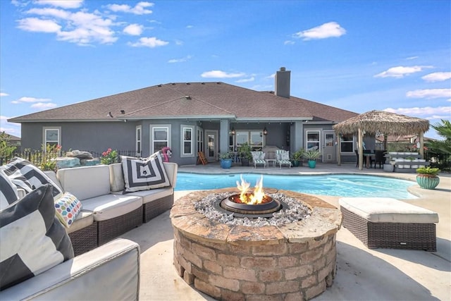 outdoor pool with an outdoor living space with a fire pit and a patio area