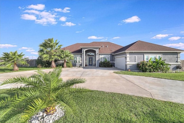 view of front of property with a garage, driveway, and stucco siding