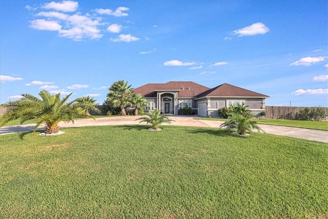 view of front facade with a front yard, fence, and driveway