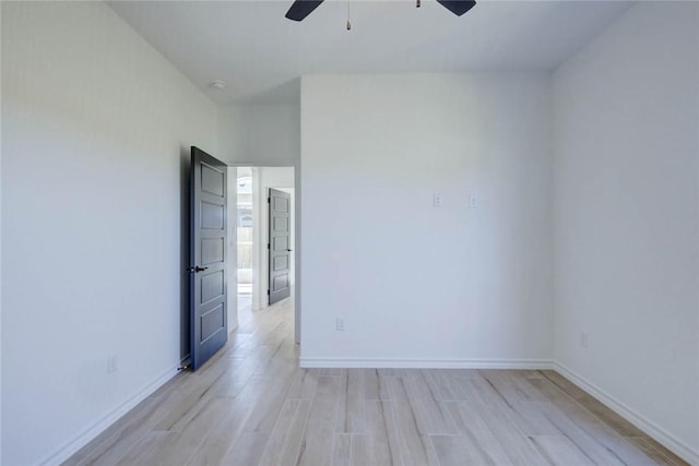 empty room with ceiling fan and light hardwood / wood-style floors