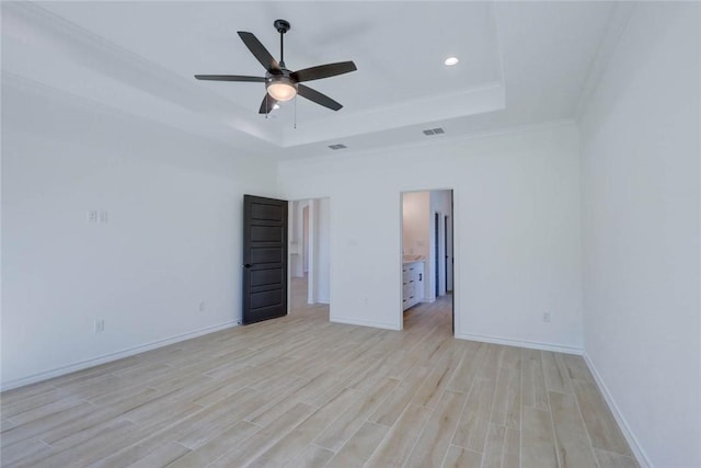 unfurnished bedroom featuring a tray ceiling, light hardwood / wood-style flooring, ceiling fan, and crown molding