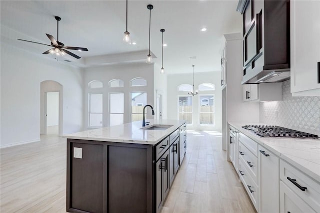 kitchen with white cabinets, pendant lighting, sink, and stainless steel gas cooktop