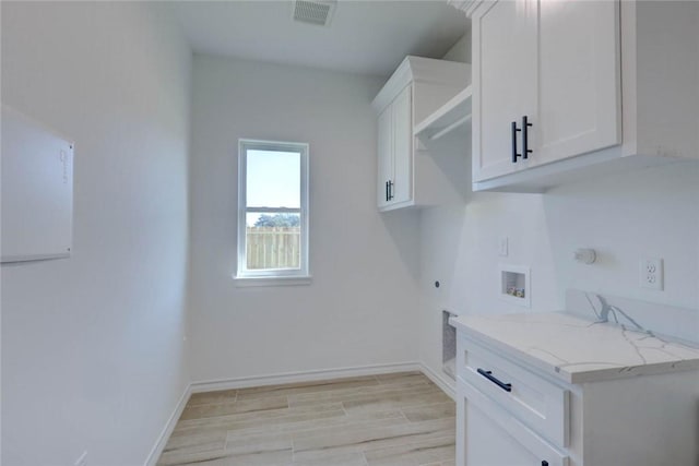 clothes washing area featuring electric dryer hookup, gas dryer hookup, hookup for a washing machine, and cabinets