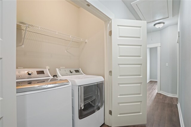 clothes washing area featuring washing machine and clothes dryer and dark hardwood / wood-style floors