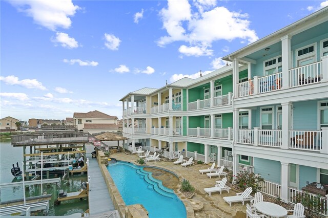 view of swimming pool with a patio area and a water view