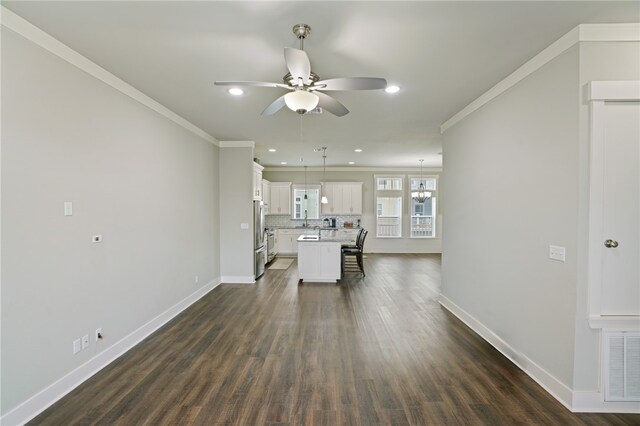 unfurnished dining area with ornamental molding, dark wood-type flooring, and ceiling fan