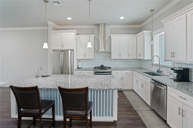 kitchen with stainless steel appliances, a center island, white cabinets, hanging light fixtures, and sink