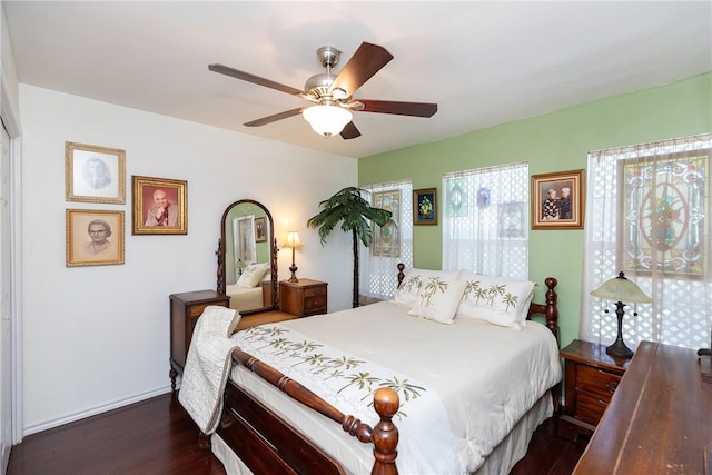 bedroom featuring ceiling fan, baseboards, and dark wood finished floors