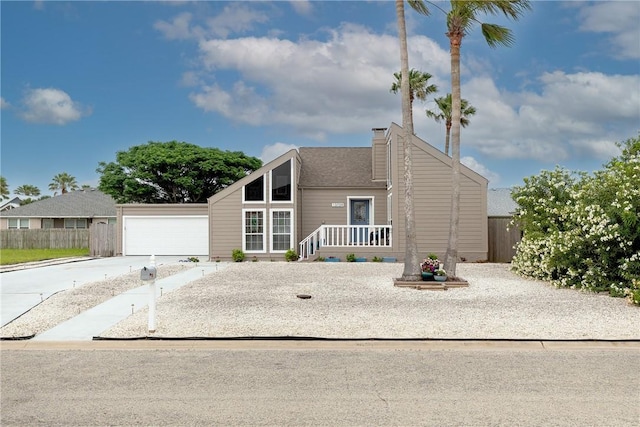 mid-century modern home featuring driveway, an attached garage, fence, and a chimney