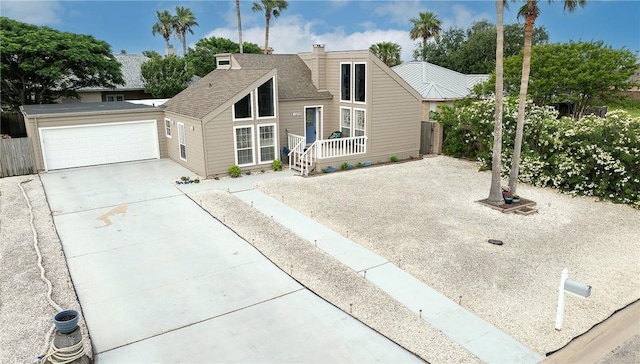 mid-century modern home featuring a shingled roof and concrete driveway