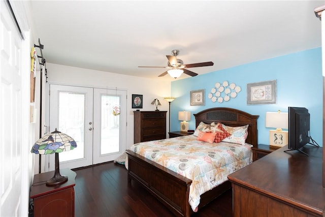 bedroom featuring ceiling fan, a barn door, dark wood finished floors, french doors, and access to outside