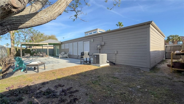 rear view of property with central AC, a fenced backyard, and a patio area