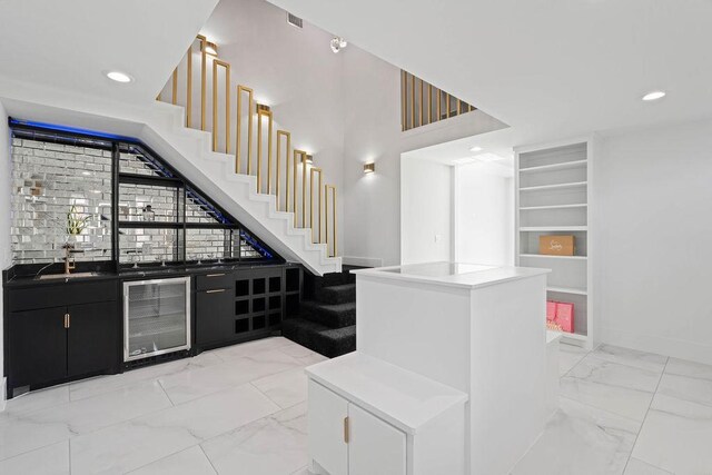 5402 Bonanza Dr, Corpus Christi, TX 78414 - indoor wet bar featuring wine cooler, light marble finish floors, recessed lighting, stairway, and baseboards