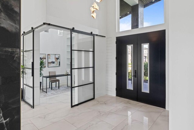 5402 Bonanza Dr, Corpus Christi, TX 78414 - foyer featuring a barn door, marble finish floors, french doors, and a high ceiling