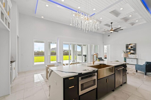 5402 Bonanza Dr, Corpus Christi, TX 78414 - kitchen featuring open floor plan, a towering ceiling, a sink, light marble finish floors, and a kitchen island with sink
