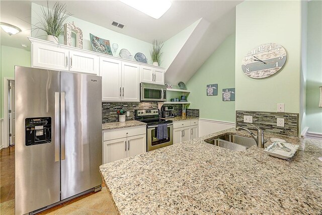 kitchen with a sink, decorative backsplash, stainless steel appliances, and white cabinets