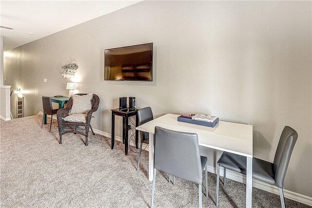 carpeted dining space featuring baseboards