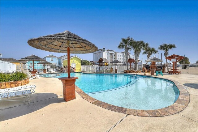 community pool with fence and a patio area