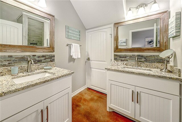 bathroom with a sink, decorative backsplash, and lofted ceiling