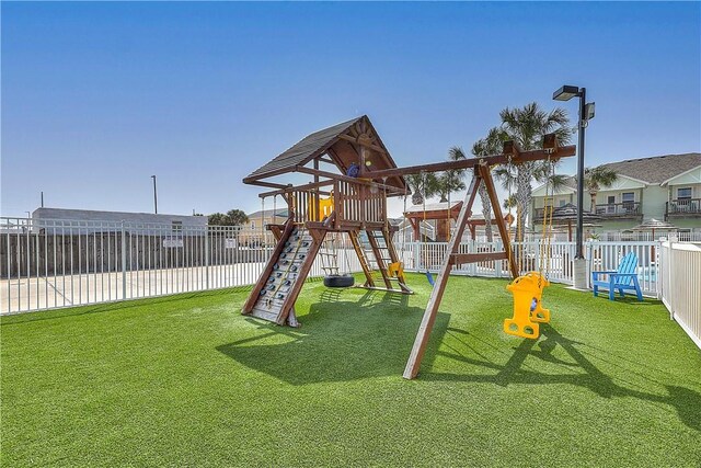 view of jungle gym with fence private yard and a yard