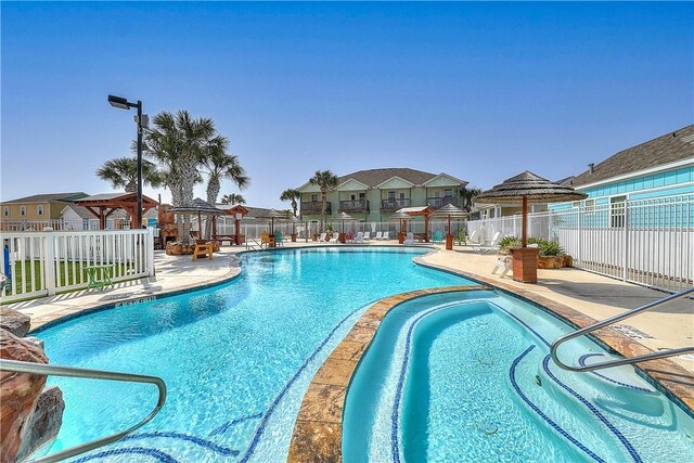 pool with fence, a gazebo, a patio area, and a residential view