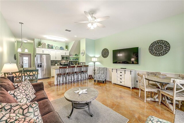 living area featuring a ceiling fan, light tile patterned flooring, and visible vents