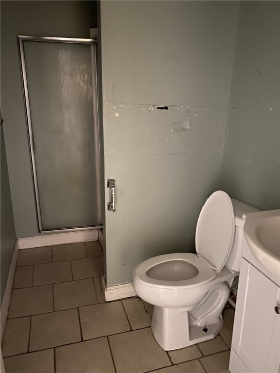 bathroom featuring toilet, an enclosed shower, vanity, and tile patterned floors