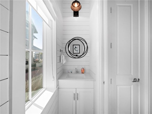 bathroom featuring vanity and wood walls