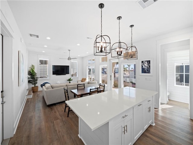 kitchen with visible vents, white cabinets, and dark wood-type flooring