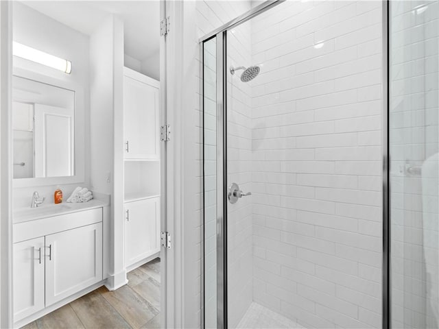bathroom with a shower stall, vanity, and wood finished floors
